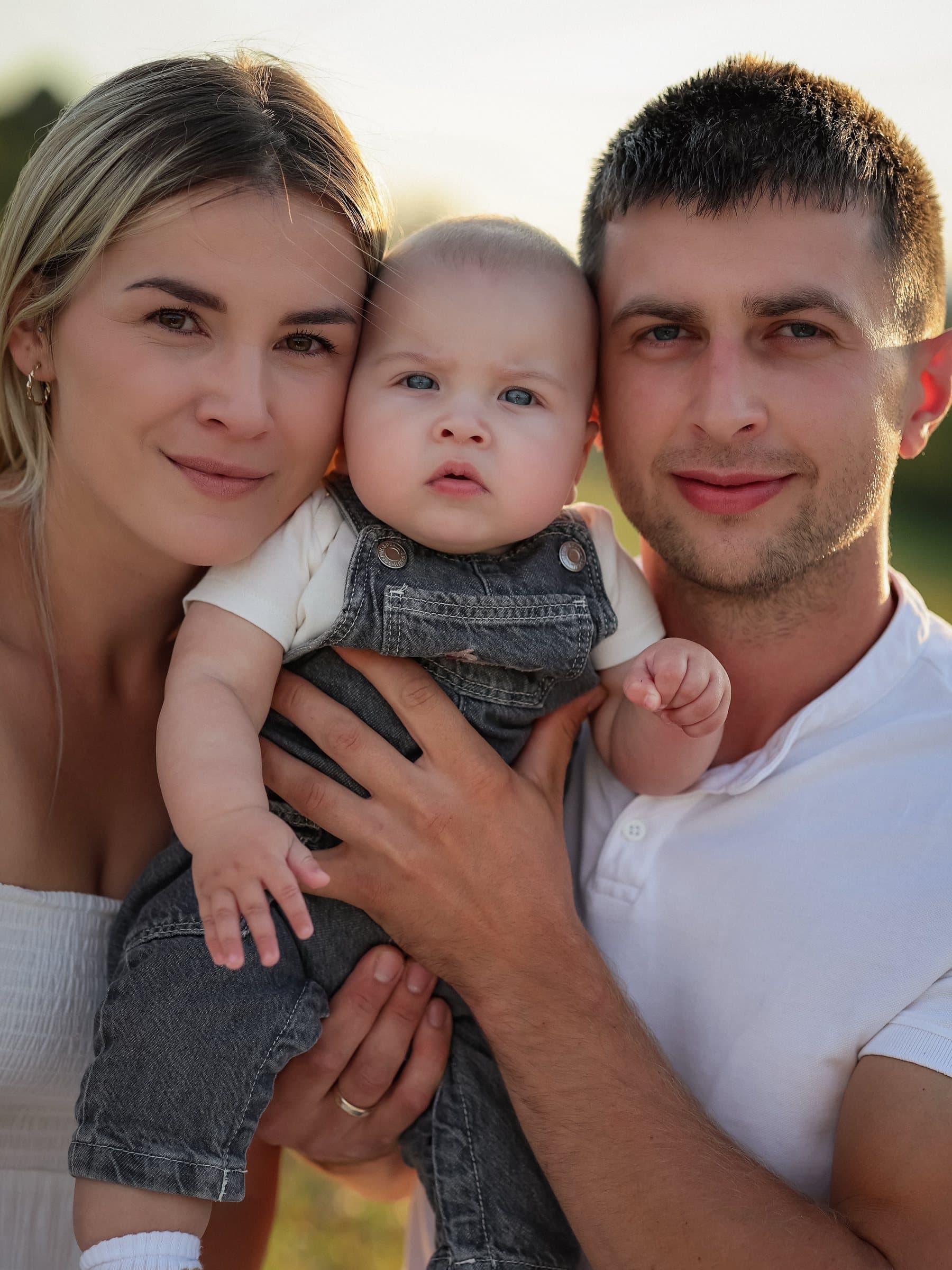 Rodzice z uśmiechniętym niemowlęciem podczas sesji rodzinnej w Gródku nad Dunajcem